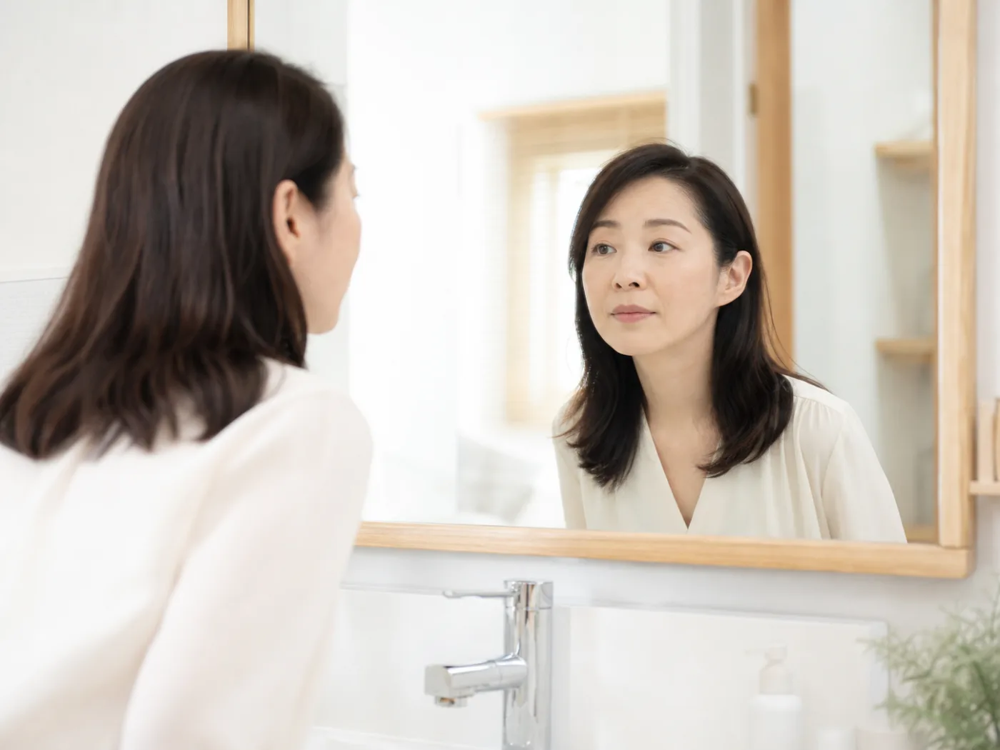 洗面台の鏡で歯ぐきを気にする女性